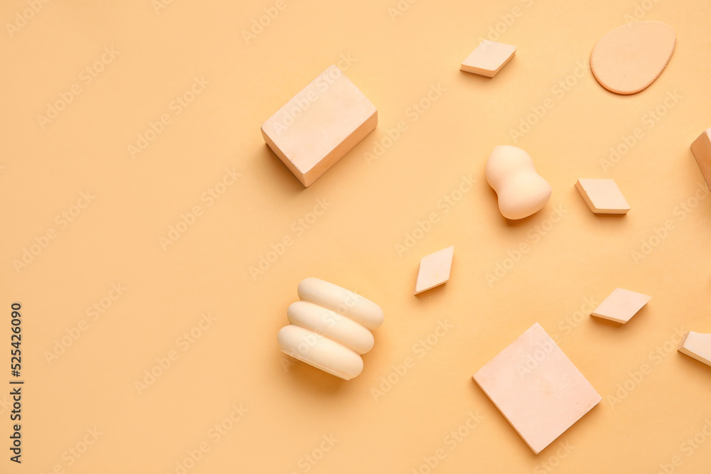 Makeup sponges with decor on beige background