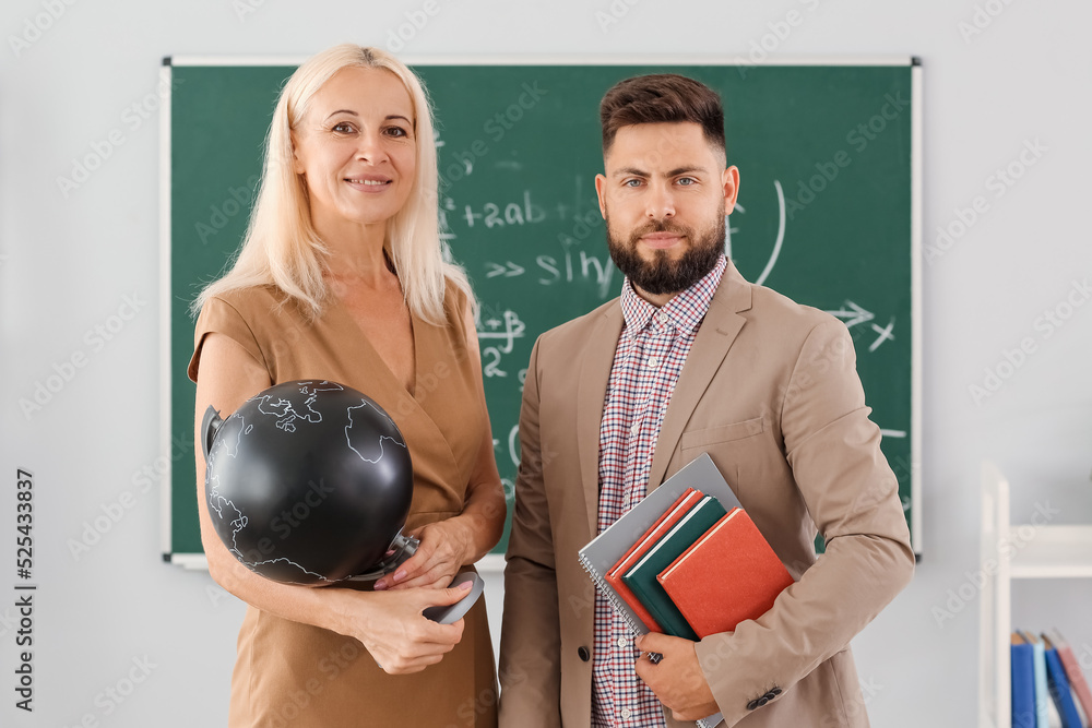 Teachers with globe and books in classroom