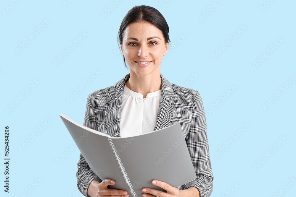 Female teacher with notebook on blue background