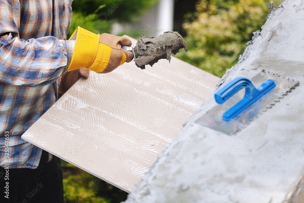 A worker with gloves lays down and dismantles the ceramic tiles of the stairs