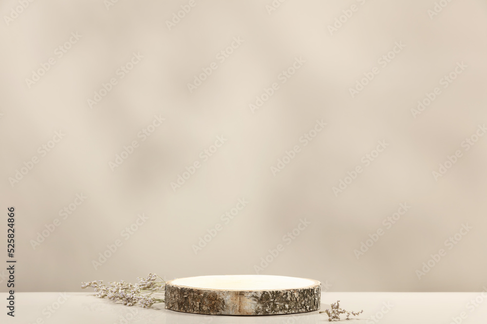 Wood slice podium and dry flowers on beige background for cosmetic product mockup