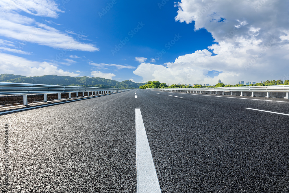 Asphalt road and green forest with mountain background