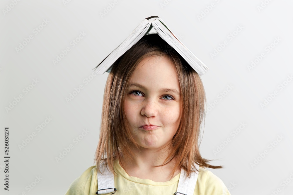 Cute adorable toddler smiling happy stand holding book over head