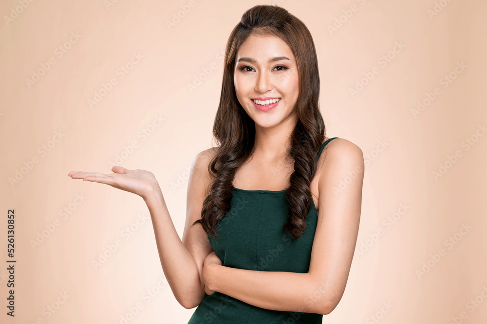 Portrait of ardent woman looking at camera, holding empty space for product, advertising text place,