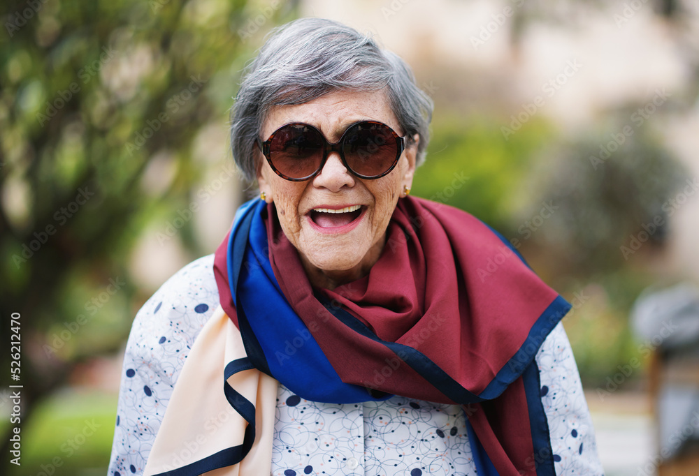 Portrait of happy old woman laughing wearing sunglasses