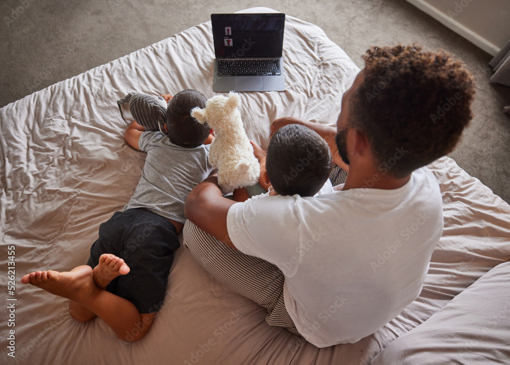 Technology, man and children relax on bed together to bond and have fun on the weekend. Happy father