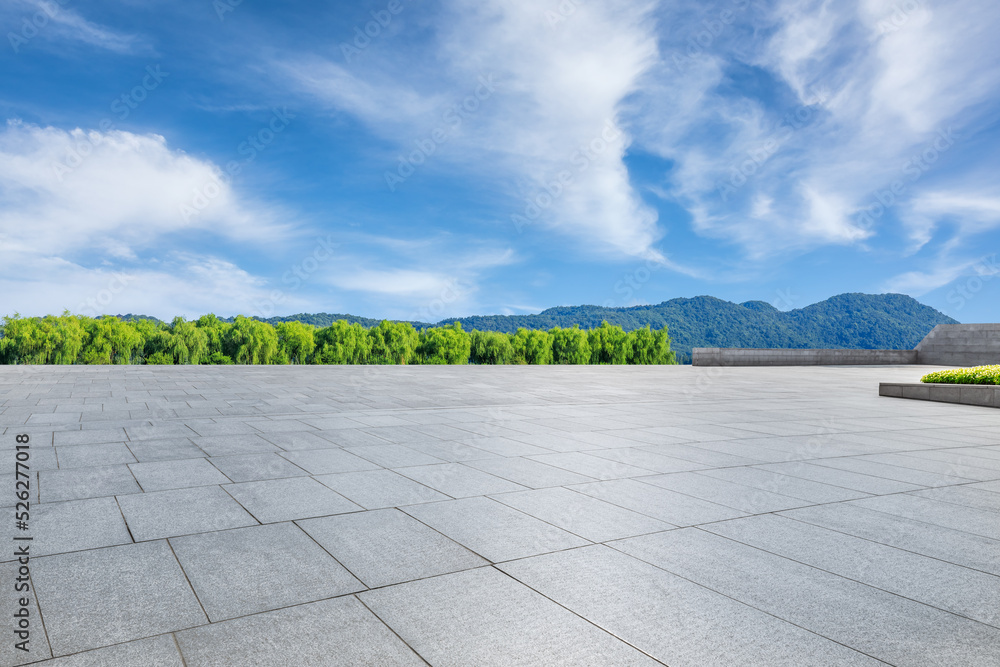 Empty square floor and green forest with mountain scenery under blue sky