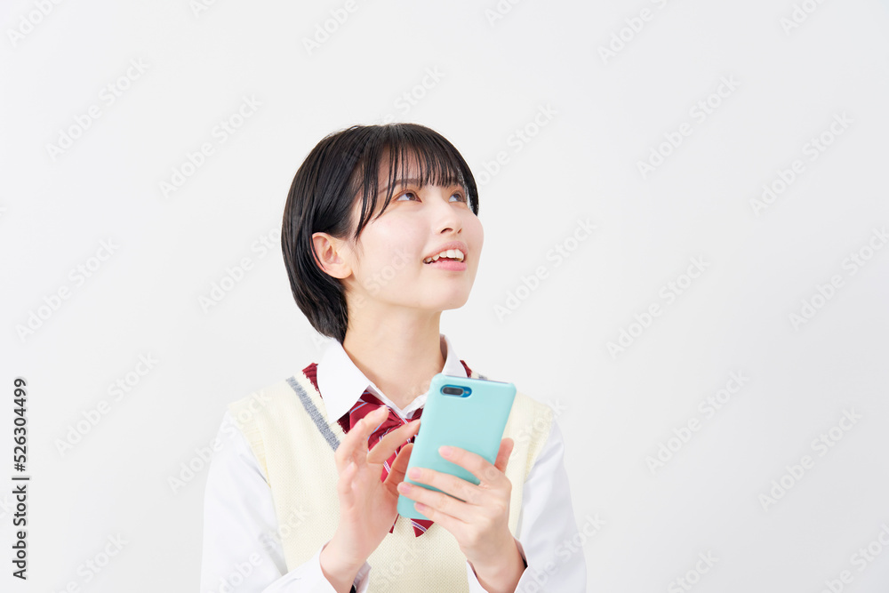 白背景でスマホを使う女子高生