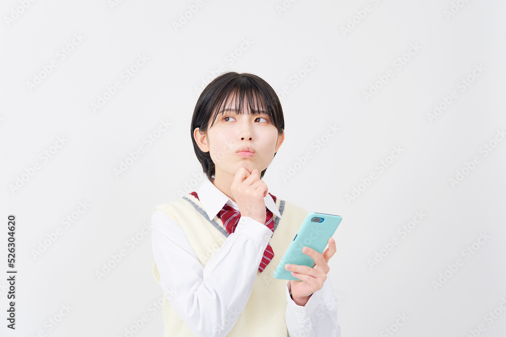 白背景でスマホを持って悩む女子高生