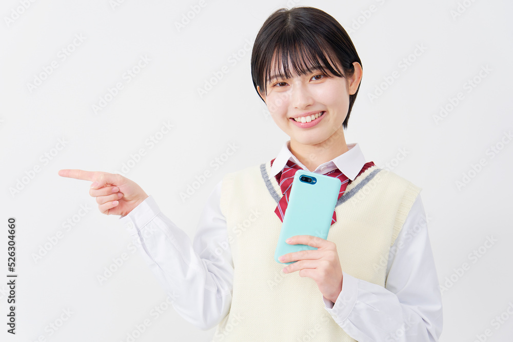 白背景でスマホを持って左を指差す女子高生