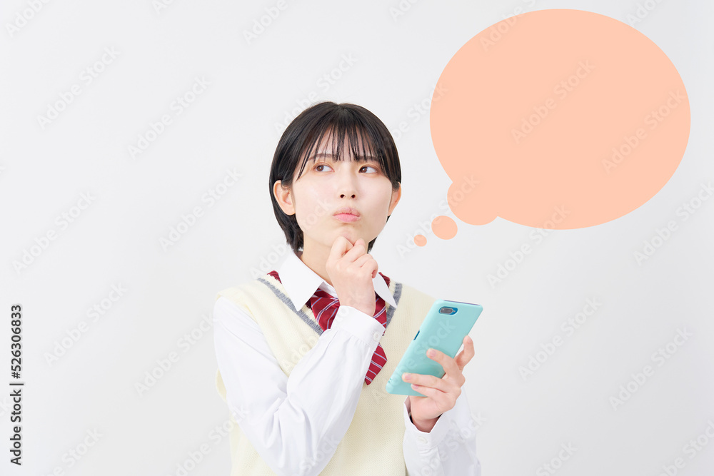 白背景でスマホを持って悩む女子高生