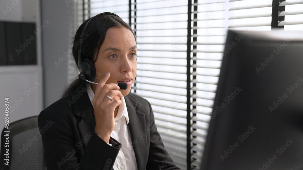 Competent female operator working on computer and talking with clients. Concept relevant to both cal