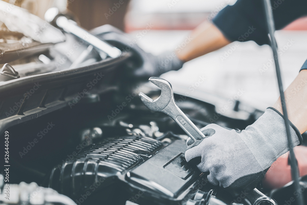 Mechanic works on the engine of the car in the garage. Repair se