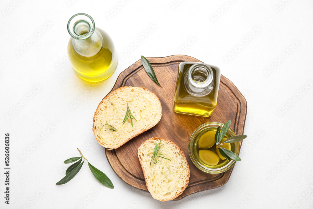 Composition with bottles of fresh olive oil and bread on light background