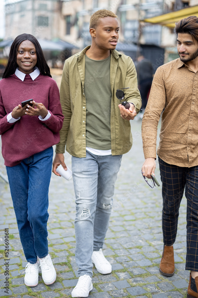 多种族学生在户外行走。英俊的微笑男女。花时间换衣服的概念