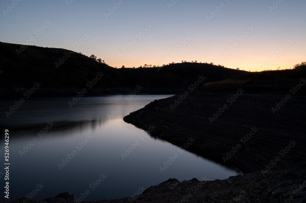 Coucher de soleil sur le lac Villerest dans le département de la Loire en été avec des reflets sur l