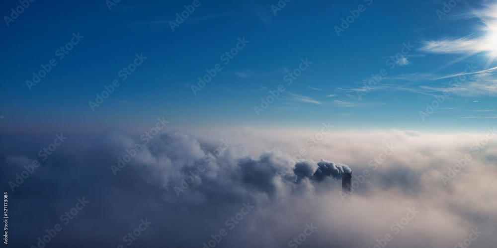 工厂管道高出云层。有害排放物进入高层大气。