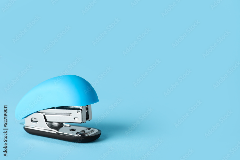 Blue stapler on color background