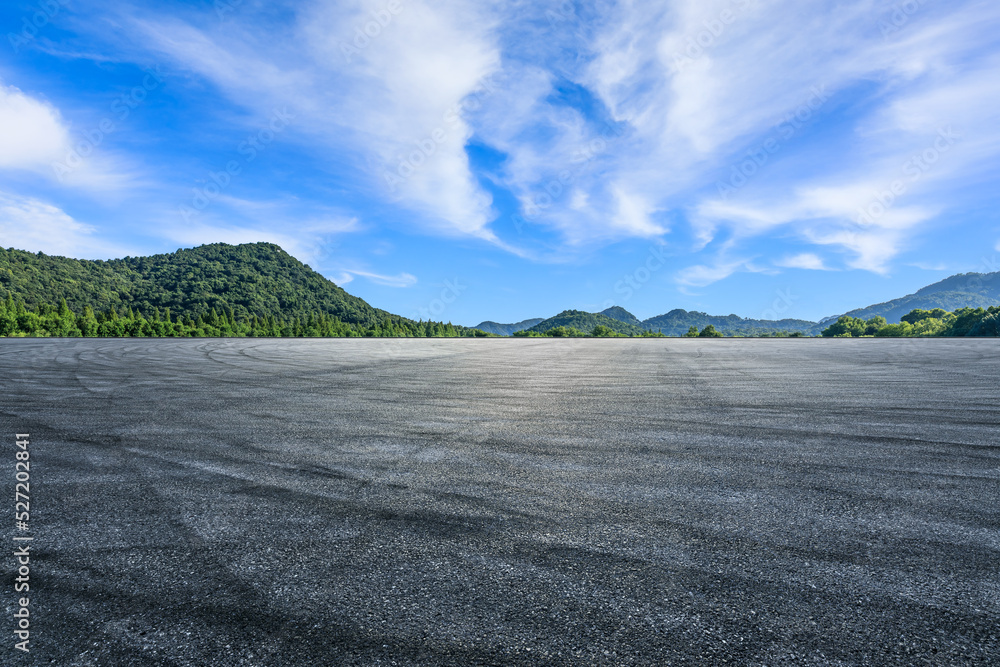 Asphalt road platform and green mountains with sky clouds background