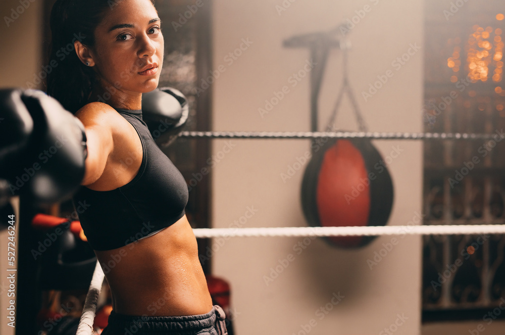 Female athlete looking at the camera in a boxing gym