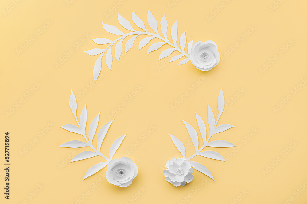 Frame made of paper flowers with leaves on yellow background