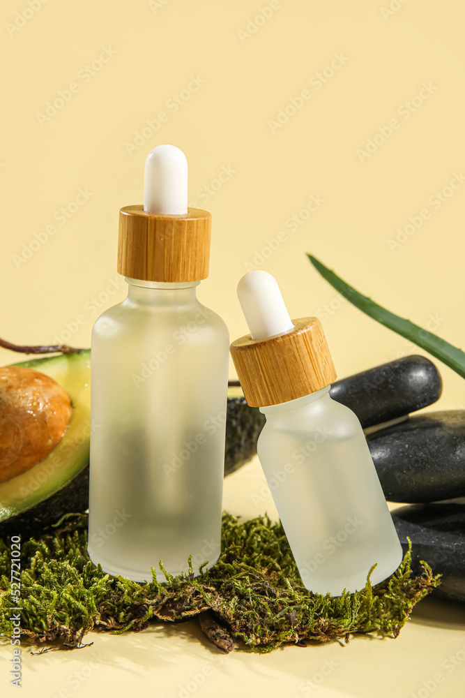 Bottles with essential oil on color background, closeup