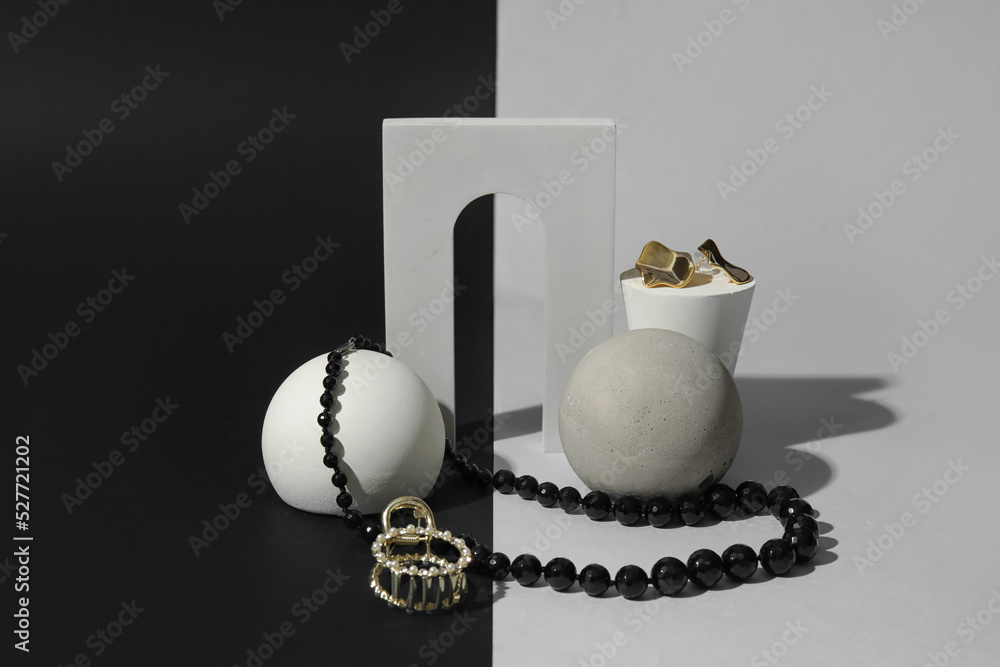 Showcase pedestals with stylish jewelry on dark background