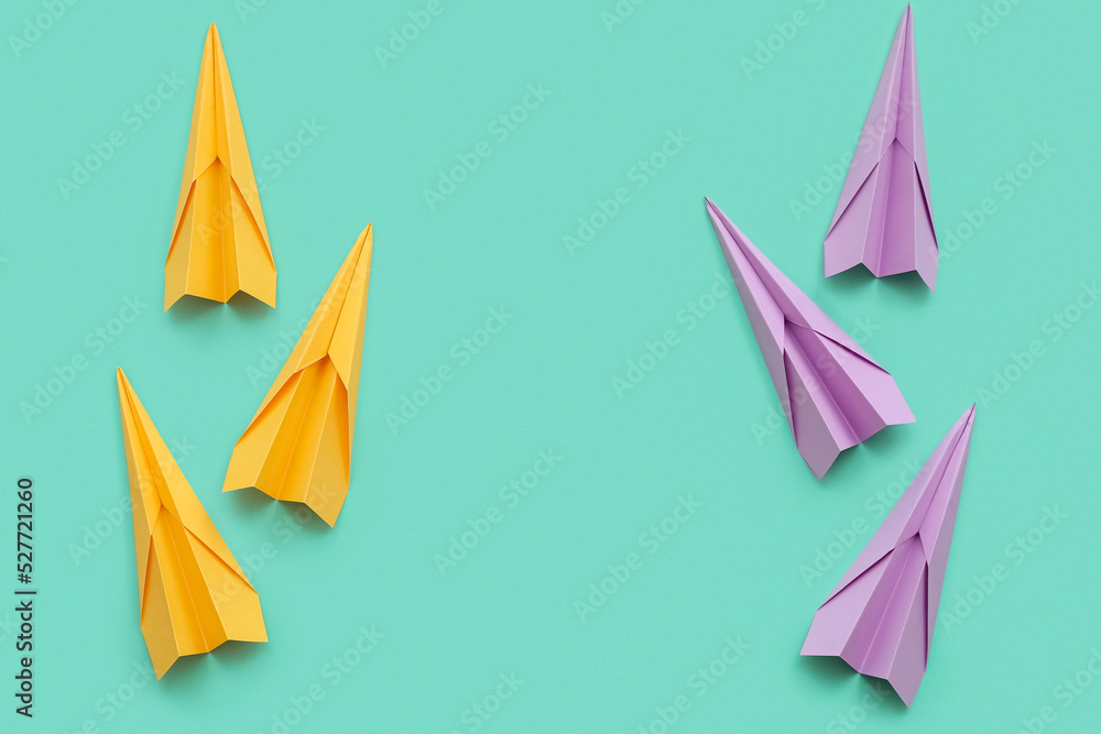 Frame made of paper planes on color background