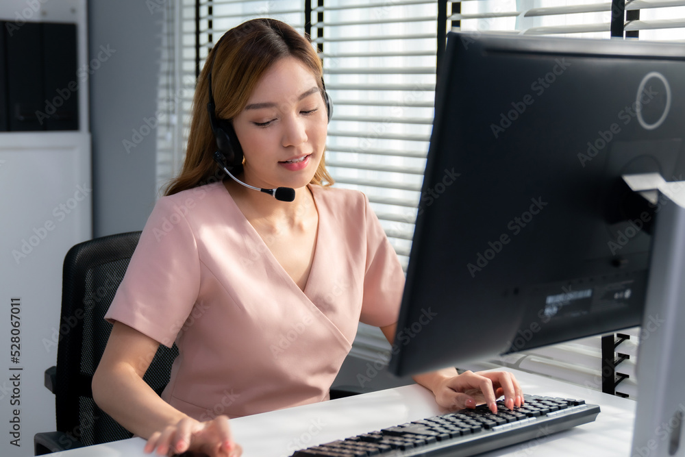 Competent female operator working on computer and while talking with clients. Concept relevant to bo