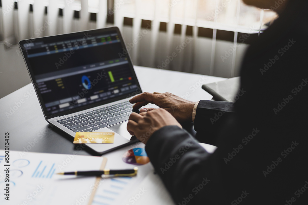 Businessman in office working on laptop analyzing finance and accounting.