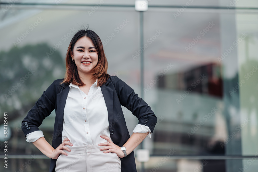 亚洲商业女性在户外叉腰微笑的肖像