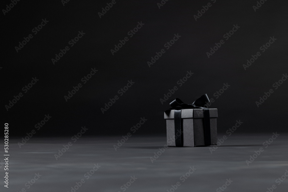 Composition of present with black ribbon on gray background