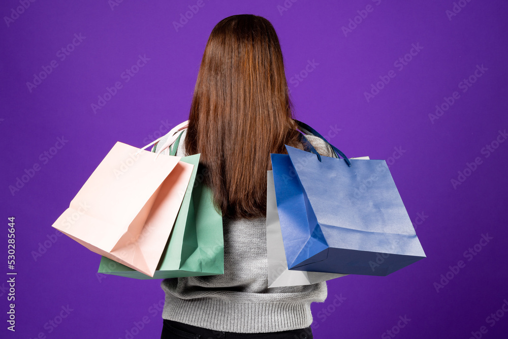 Composition of woman holding shopping bags on blue background