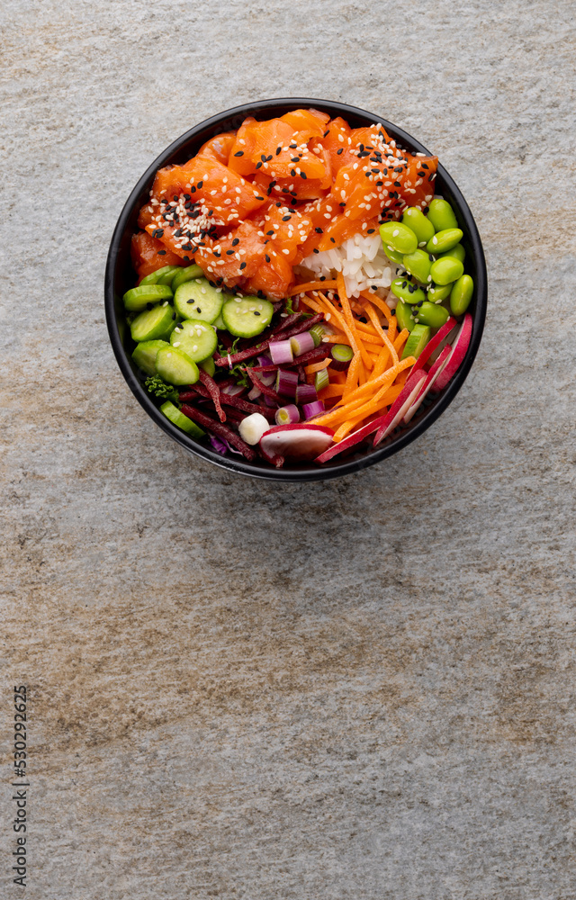 Overhead view of hawaiian poke bowl with copy space on grey background