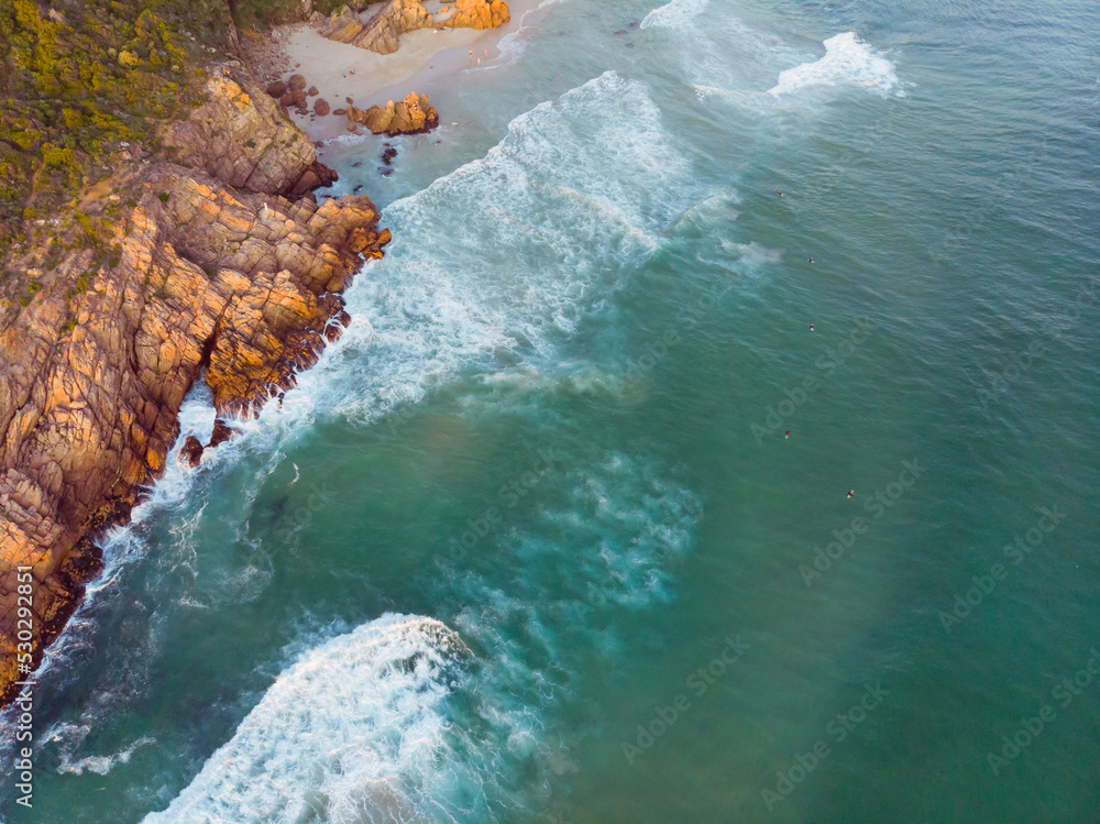 High angle view of sea waves and sea shore with rocky cliff shore