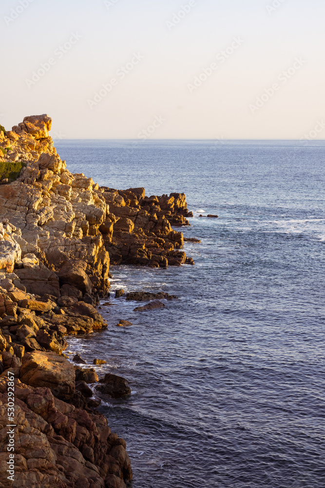 海浪和海岸的景观，岩石，蓝色无云的天空和地平线