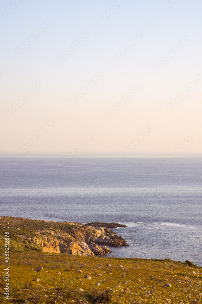 平静的大海和海岸，岩石，蓝色无云的天空和地平线的景观