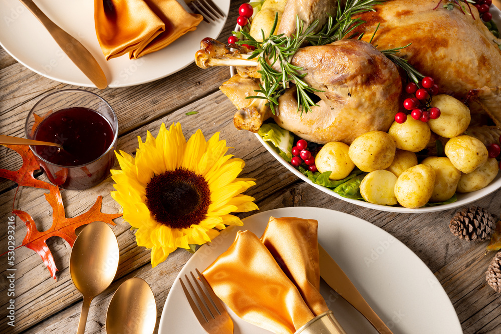 Overhead view of thanksgiving table with roast turkey, potatoes, candles and autumn decoration