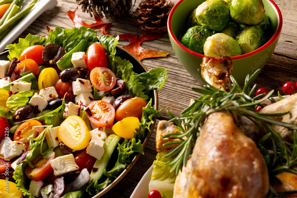 Overhead view of thanksgiving table with roast turkey, vegetables and autumn decoration on wood