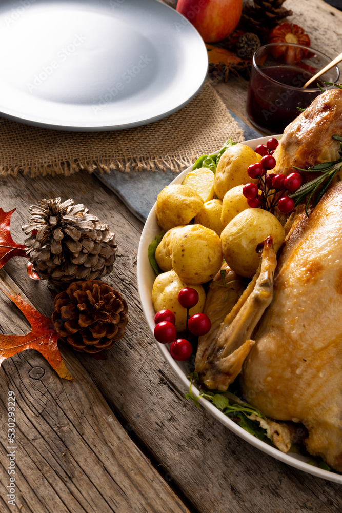 Close up of thanksgiving table with roast turkey, potatoes and autumn decoration on wood