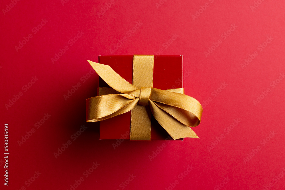 Image of red christmas gift decoration and copy space on red background