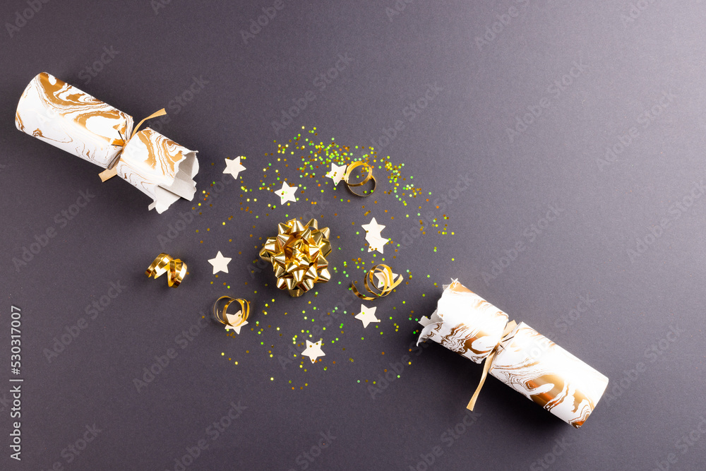 Image of christmas cracker with christmas decoration and copy space on grey background