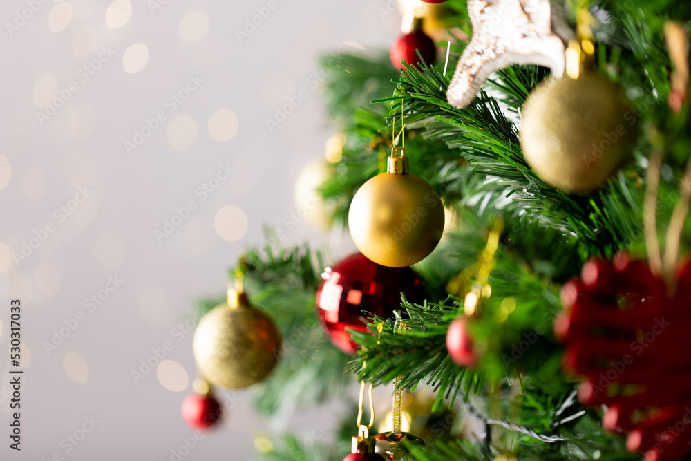 Image of christmas tree with baubles decoration and copy space on grey background