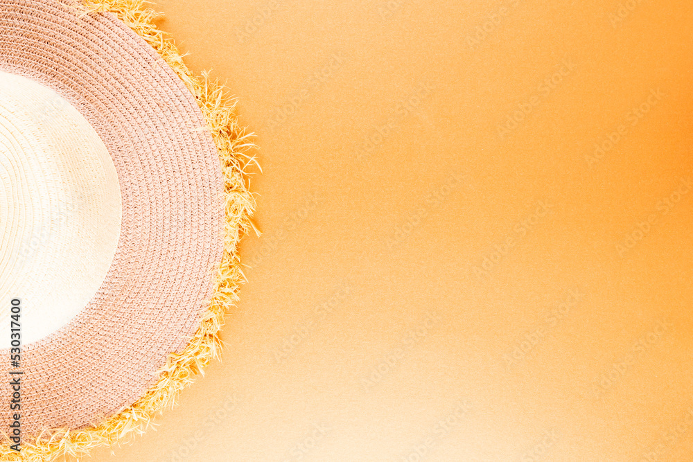 Image of straw hat lying on yellow surface