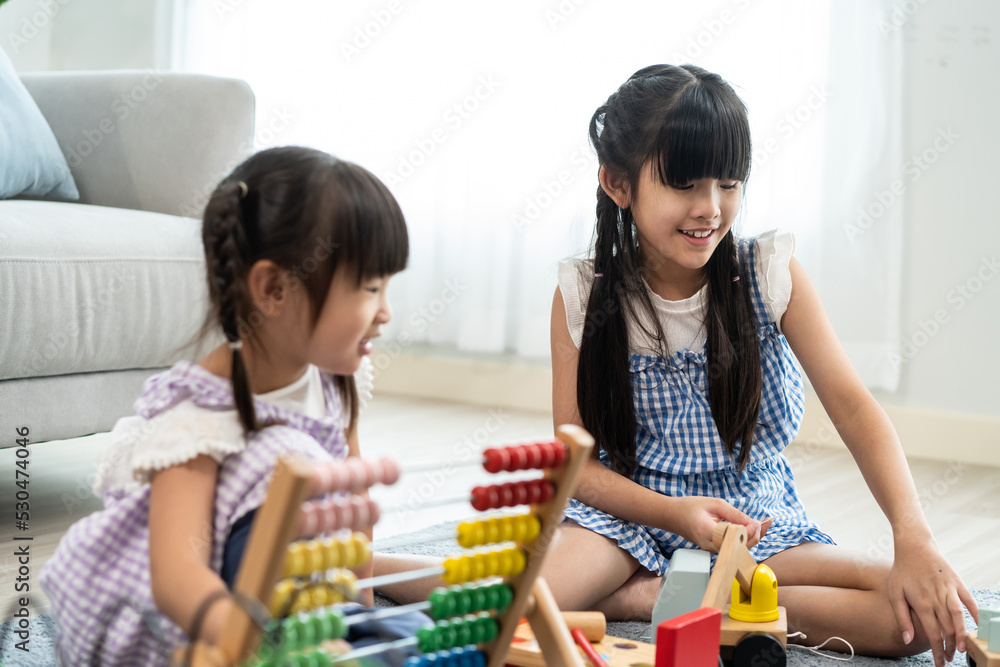 Asian young girl sibling playing toys together in living room at home