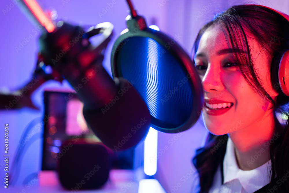 Asian young audio DJ woman sing a song on microphone to broadcasting