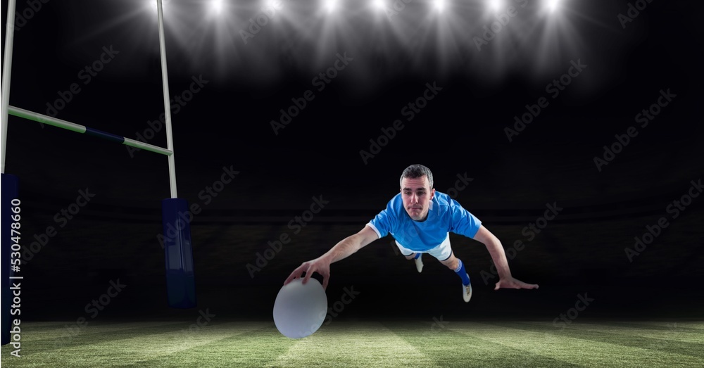 Composition of male rugby player diving holding ball on rugby pitch