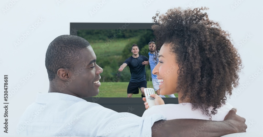 Composition of two male and female sports fans watching football match on tv