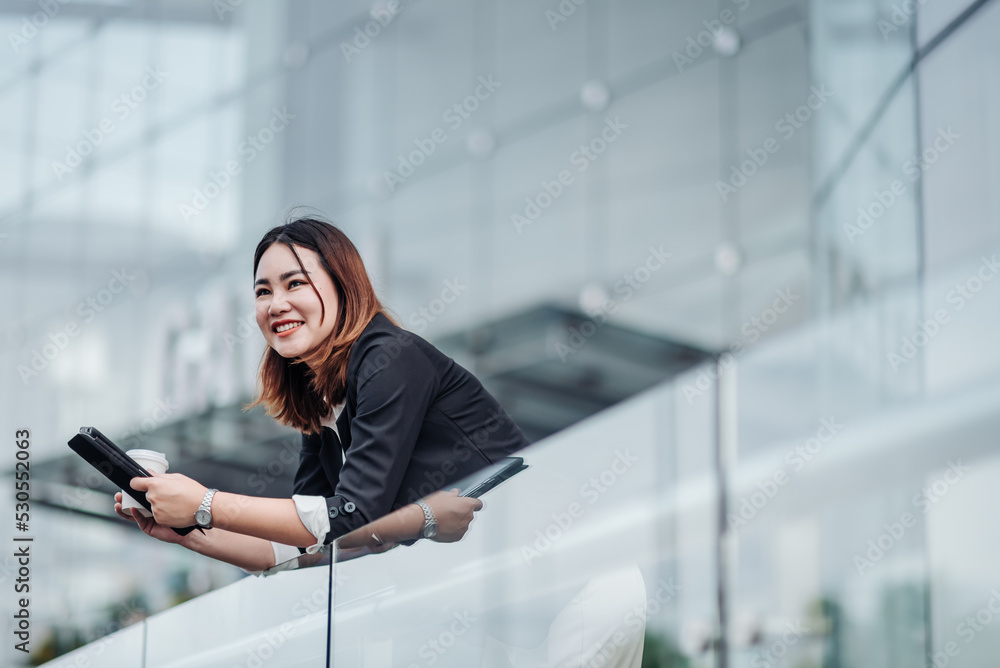 年轻的亚洲女商人在出差前使用平板电脑坐在机场。漂亮女人