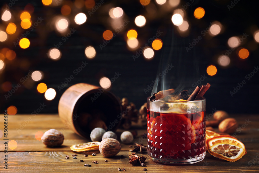 Glass of delicious mulled wine on wooden table